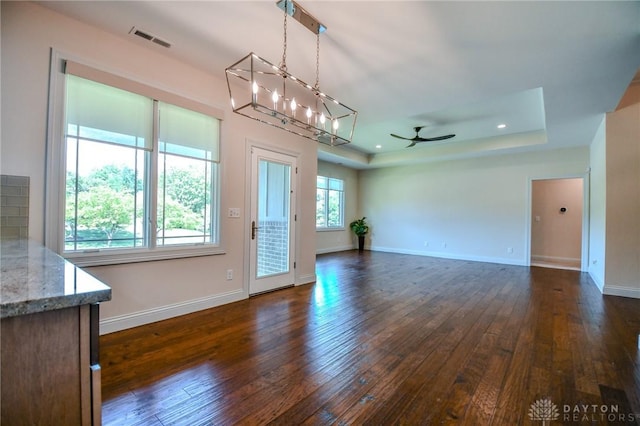2725 Terraceview Cir, Beavercreek, OH 45431 - unfurnished living room featuring a tray ceiling, a chandelier, dark wood-type flooring, a ceiling fan, and recessed lighting