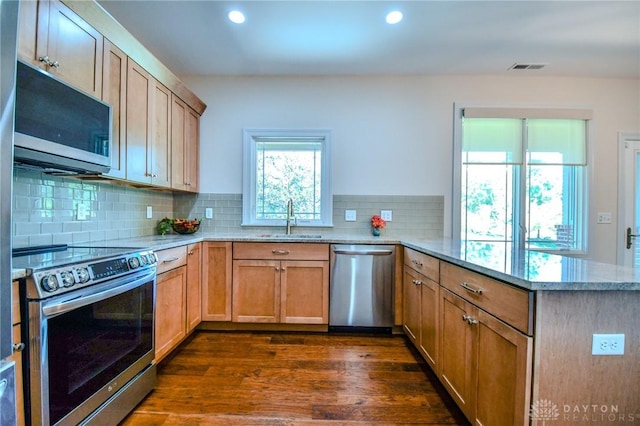 2725 Terraceview Cir, Beavercreek, OH 45431 - kitchen with appliances with stainless steel finishes, a peninsula, light stone counters, recessed lighting, and dark wood-type flooring