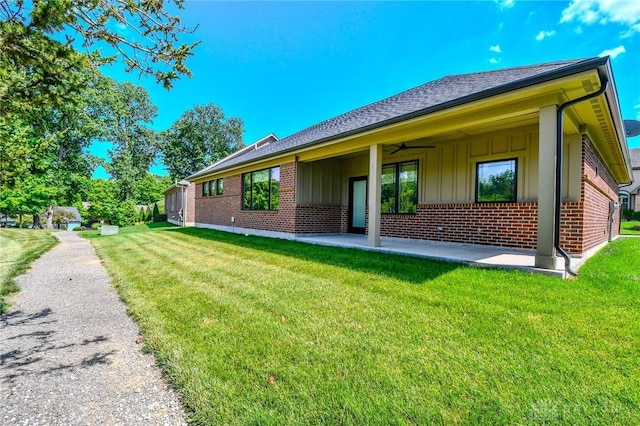 2725 Terraceview Cir, Beavercreek, OH 45431 - rear view of house featuring board and batten siding, brick siding, a yard, and a patio area