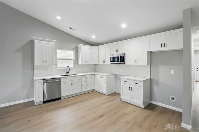 2061 Pine Forest Dr, Miamisburg, OH 45342 - kitchen featuring visible vents, appliances with stainless steel finishes, a sink, white cabinets, and lofted ceiling