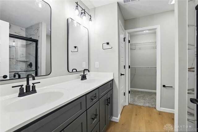 2061 Pine Forest Dr, Miamisburg, OH 45342 - bathroom featuring a sink, double vanity, a stall shower, and wood finished floors