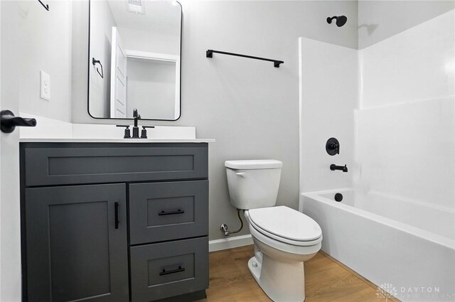 2061 Pine Forest Dr, Miamisburg, OH 45342 - bathroom featuring vanity, wood finished floors, toilet, baseboards, and bathtub / shower combination