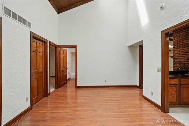 734 Pine Needles Dr, Washington Twp, OH 45458 - interior space featuring visible vents, wood finished floors, high vaulted ceiling, baseboards, and a textured wall