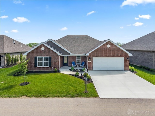 838 W Bentley Cir, Troy, OH 45373 - view of front of home with brick siding, a front lawn, concrete driveway, an attached garage, and a shingled roof
