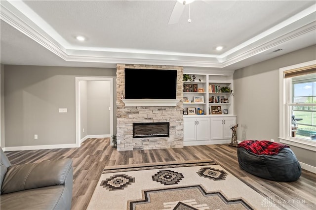 838 W Bentley Cir, Troy, OH 45373 - living room featuring wood finished floors, a fireplace, baseboards, a raised ceiling, and a ceiling fan