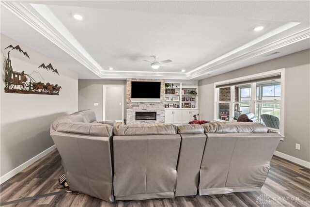 838 W Bentley Cir, Troy, OH 45373 - living room with dark wood-style flooring, a fireplace, baseboards, a tray ceiling, and a ceiling fan