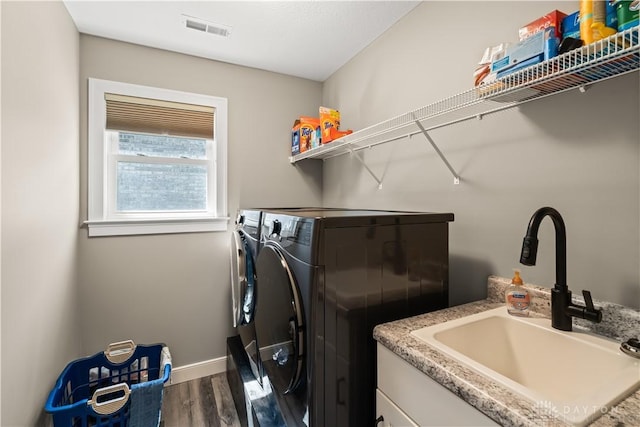 838 W Bentley Cir, Troy, OH 45373 - clothes washing area featuring laundry area, visible vents, wood finished floors, a sink, and separate washer and dryer