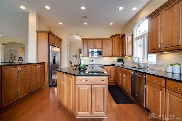 835 Vintage Green Way, Centerville, OH 45458 - kitchen featuring appliances with stainless steel finishes, a sink, arched walkways, wood finished floors, and recessed lighting
