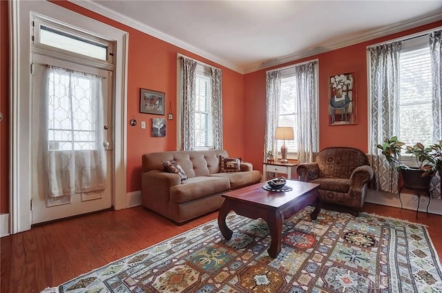 living area with crown molding, baseboards, and wood finished floors