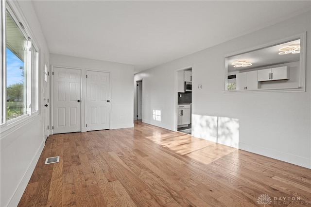 149 Poe Ln, Xenia, OH 45385 - unfurnished living room with baseboards, wood finished floors, and visible vents