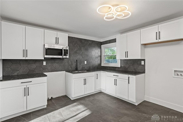 149 Poe Ln, Xenia, OH 45385 - kitchen featuring a sink, dark countertops, white cabinets, and stainless steel microwave