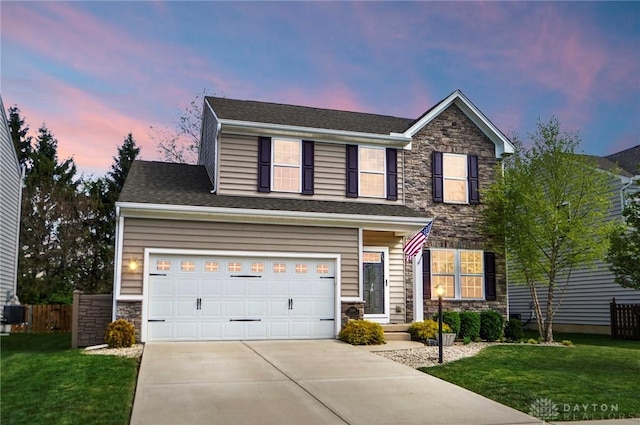 traditional home with a yard, driveway, stone siding, and fence