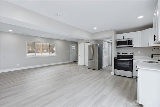 340 S Elm St, Dayton, OH 45449 - kitchen featuring a sink, light countertops, light wood-style floors, stainless steel appliances, and white cabinetry