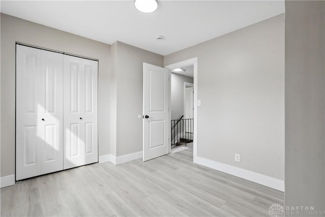 340 S Elm St, Dayton, OH 45449 - unfurnished bedroom featuring baseboards, light wood-style flooring, and a closet