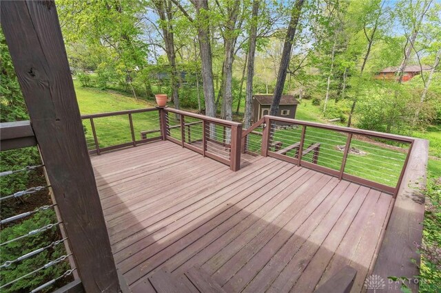 deck with a lawn, an outdoor structure, and a storage shed