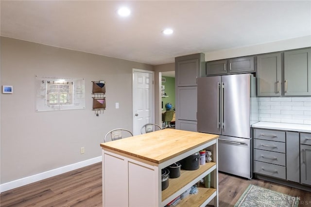 kitchen with open shelves, gray cabinets, high quality fridge, wood finished floors, and butcher block counters