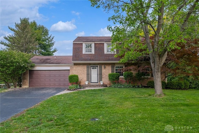 view of front of house with a front lawn, a gambrel roof, brick siding, an attached garage, and driveway