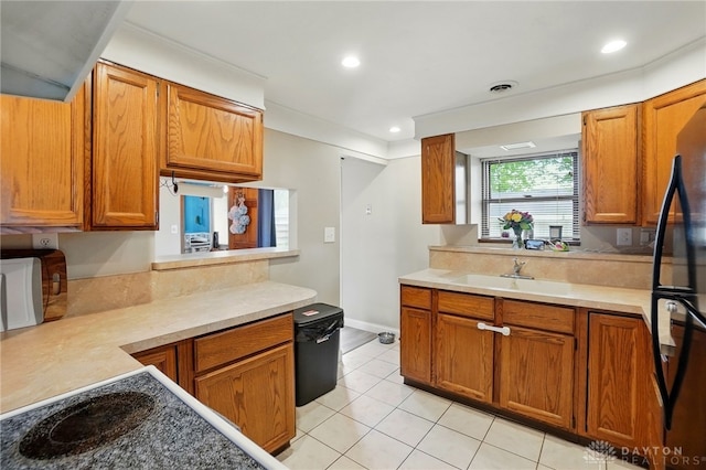 813 Kenosha Rd, Kettering, OH 45429 - kitchen featuring a sink, light countertops, brown cabinetry, and light tile patterned flooring