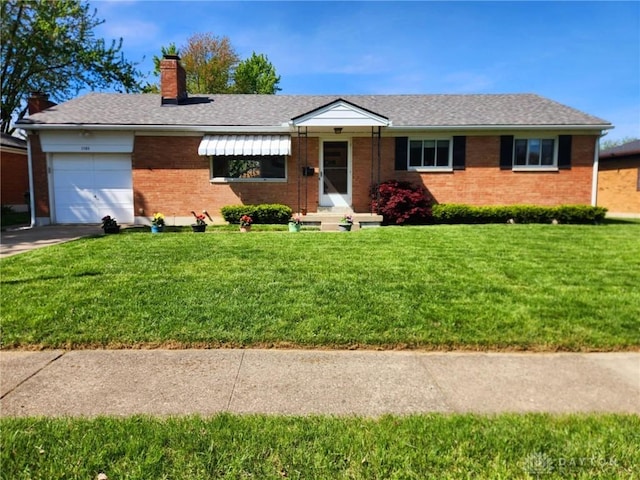 ranch-style house featuring a front lawn, a chimney, brick siding, an attached garage, and driveway