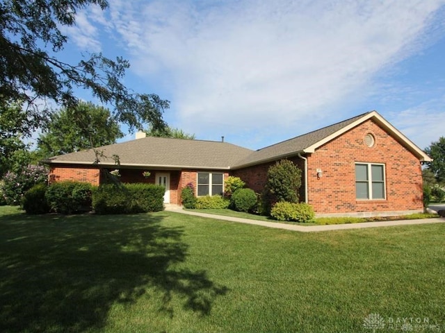 ranch-style house featuring brick siding, a front lawn, and a chimney