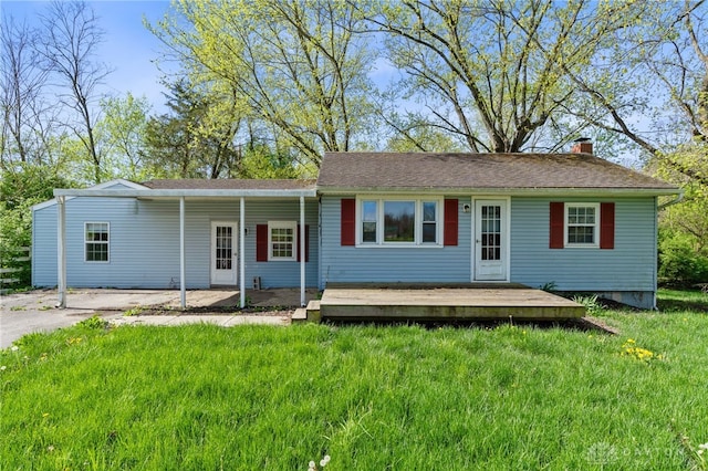 ranch-style home featuring driveway, a chimney, a front yard, and a carport