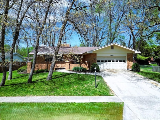 ranch-style house with fence, an attached garage, brick siding, a front yard, and concrete driveway