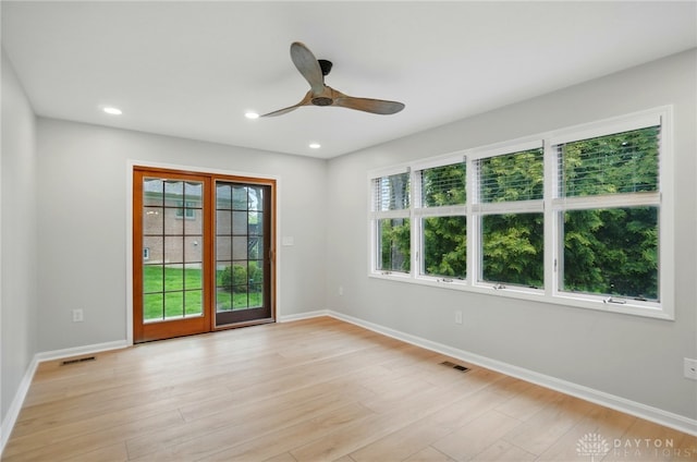 spare room featuring light wood-style floors, a ceiling fan, baseboards, recessed lighting, and visible vents