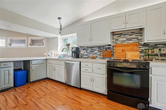 kitchen featuring light countertops, black electric range, backsplash, stainless steel dishwasher, and vaulted ceiling