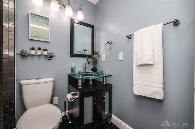 bathroom featuring vanity, baseboards, and toilet