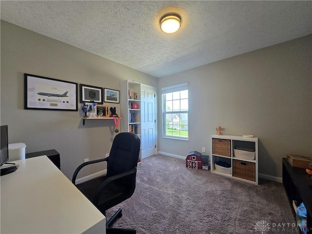 carpeted office featuring a textured ceiling and baseboards