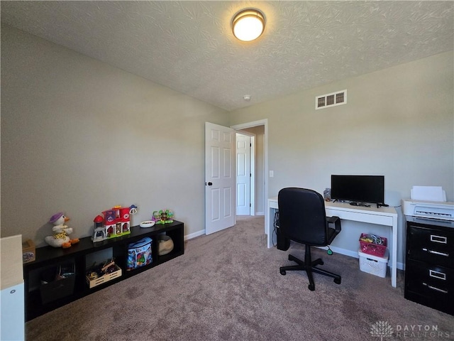 carpeted home office featuring a textured ceiling, visible vents, and baseboards