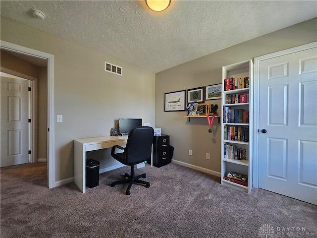 home office with baseboards, carpet, a textured ceiling, and visible vents