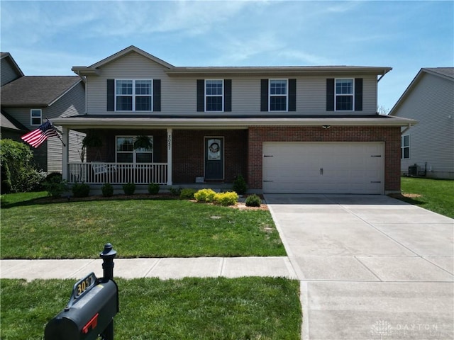 traditional-style home with a garage, a front lawn, a porch, and driveway