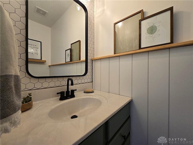 bathroom featuring visible vents, tasteful backsplash, and vanity