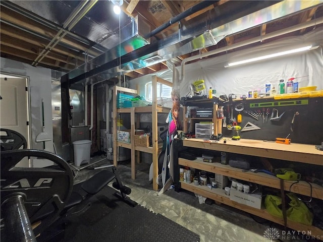 unfinished basement featuring heating unit, a workshop area, and visible vents