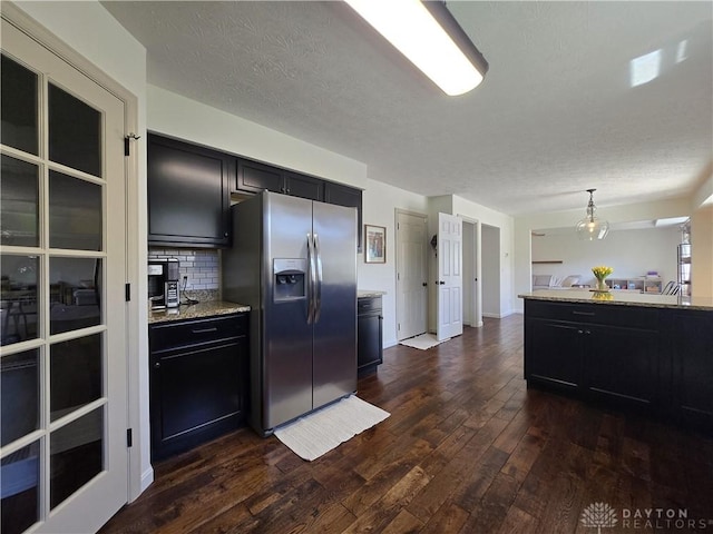 kitchen with stainless steel refrigerator with ice dispenser, dark cabinetry, and dark wood finished floors