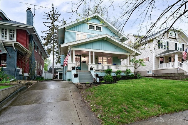 94 Patterson Rd, Oakwood, OH 45419 - traditional style home with stairway, driveway, covered porch, and a front yard