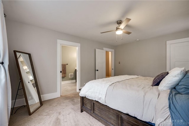94 Patterson Rd, Oakwood, OH 45419 - bedroom featuring visible vents, baseboards, ensuite bathroom, light colored carpet, and a ceiling fan