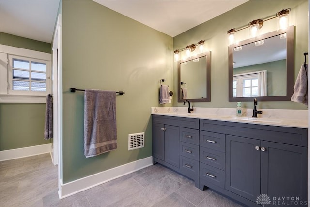 94 Patterson Rd, Oakwood, OH 45419 - full bath with double vanity, baseboards, visible vents, and a sink