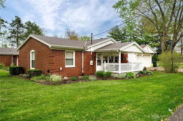9550 Paragon Rd, Dayton, OH 45458 - back of property with covered porch, brick siding, a yard, and a garage