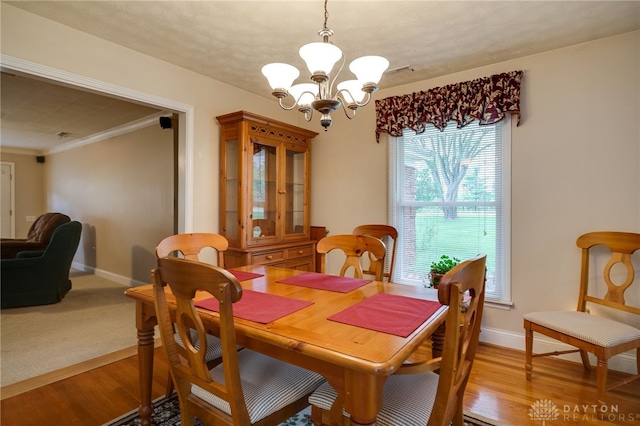 9550 Paragon Rd, Dayton, OH 45458 - dining area featuring crown molding, baseboards, light wood-style flooring, and a notable chandelier