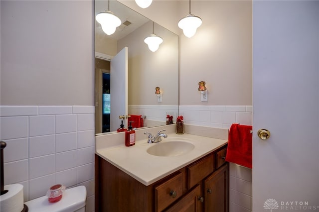 9550 Paragon Rd, Dayton, OH 45458 - bathroom with visible vents, tile walls, wainscoting, vanity, and toilet