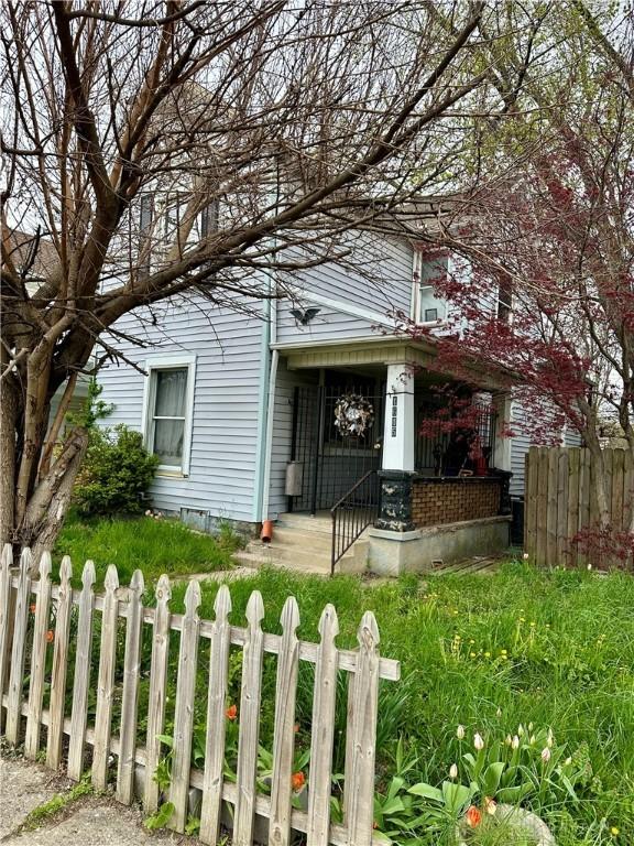view of front of house featuring fence private yard and a porch