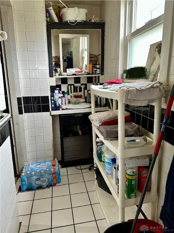 interior space with tile patterned flooring and tile walls