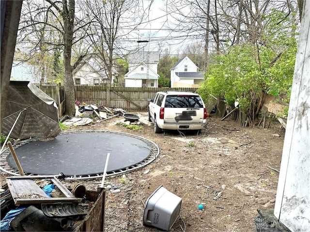 view of yard with fence and a trampoline