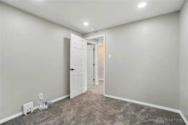 carpeted spare room featuring baseboards and recessed lighting