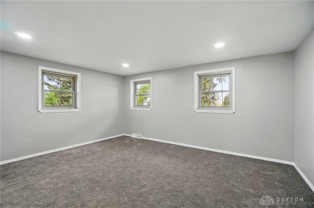 below grade area with baseboards, recessed lighting, dark carpet, and visible vents