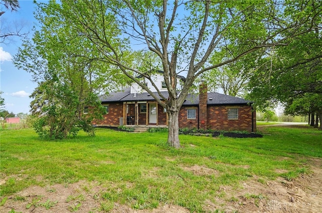 back of house with a yard and brick siding