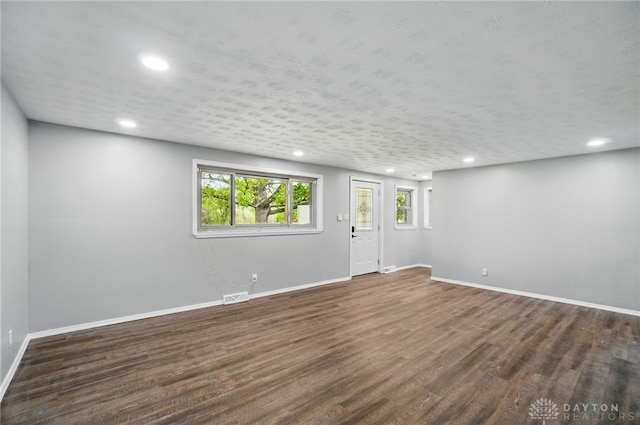 interior space featuring recessed lighting, baseboards, wood finished floors, and visible vents