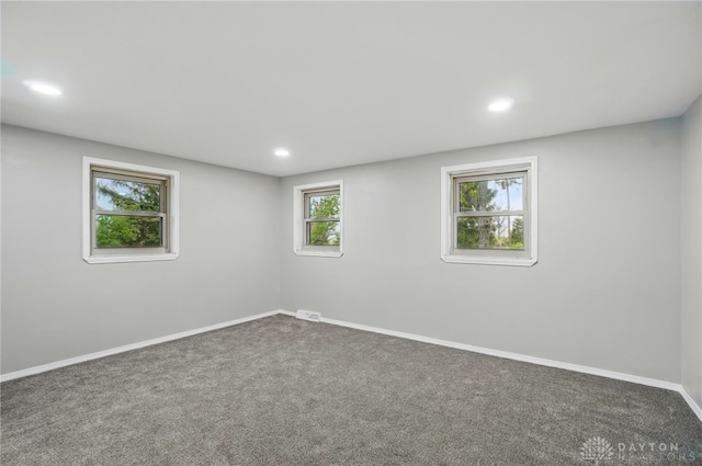 spare room with carpet floors, recessed lighting, baseboards, and visible vents
